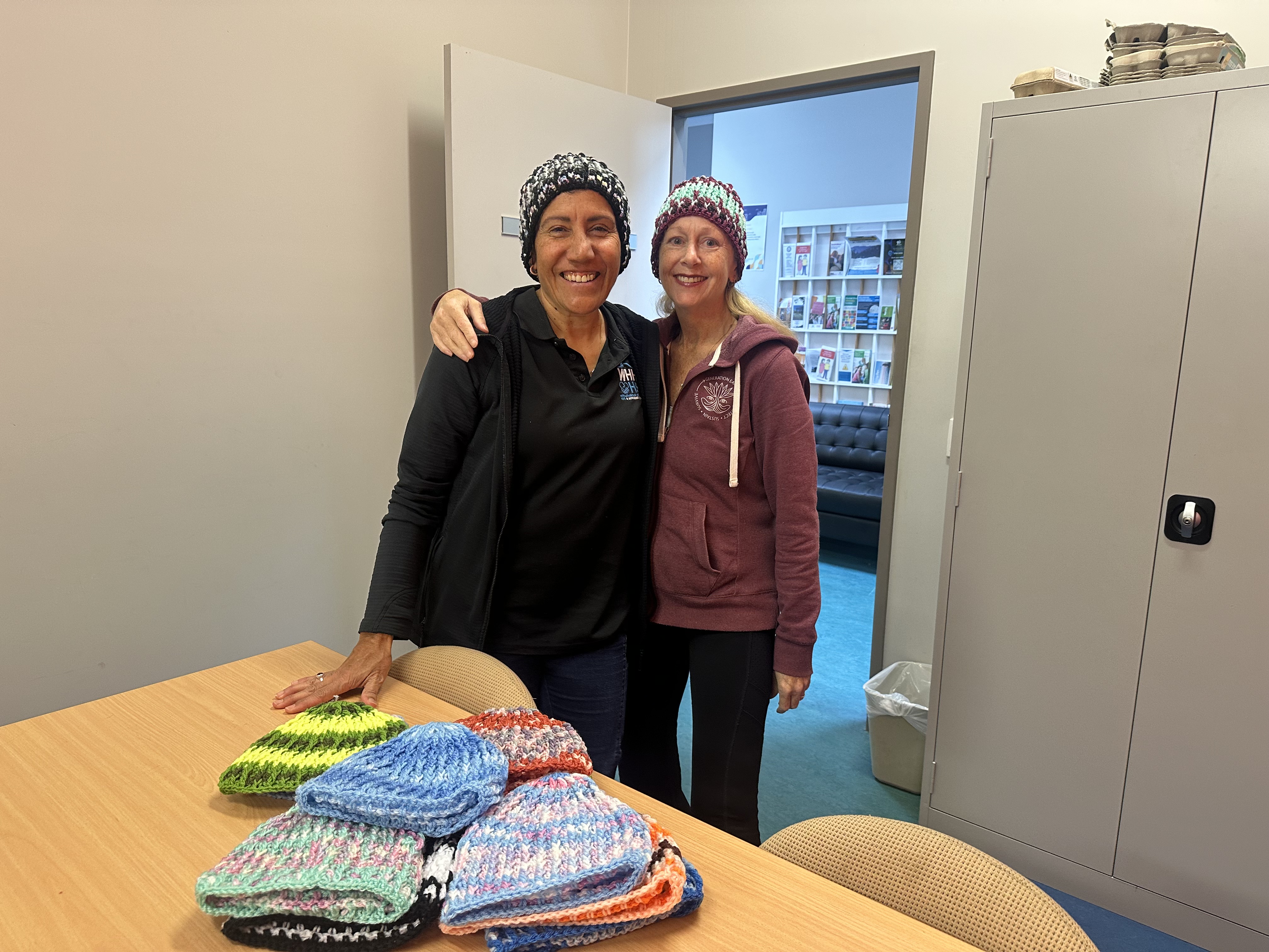Vanessa, a former client, donating hand-knitted beanies from Vera, an 84-year-old resident of Albion Park Rail